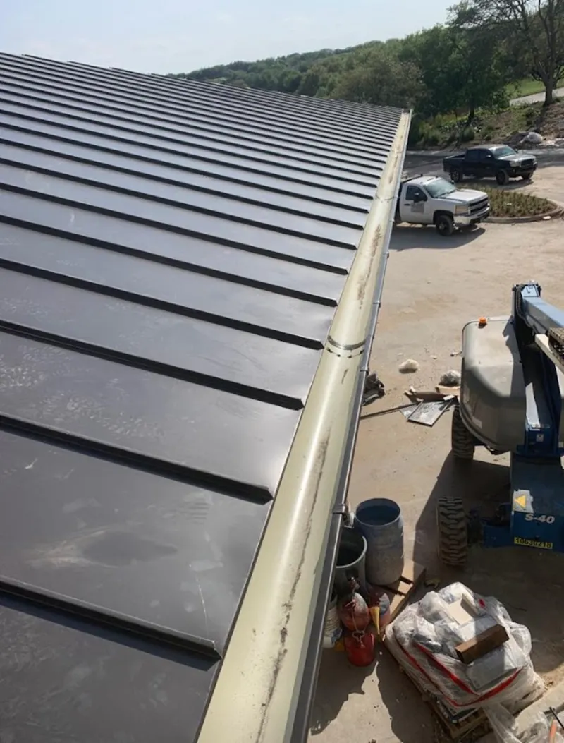 Standing seam panel and gutter detail on a metal roofing jobsite in Harvard